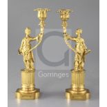 A pair of Regency gilt brass chinoiserie candlesticks, each modelled as a female figure holding a