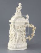 A mid 19th century German ivory tankard, carved with a procession of bacchanalian figures, putti and