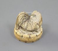 A Japanese ivory netsuke of a cockerel seated on an oval box, 19th century, the box with metal pin