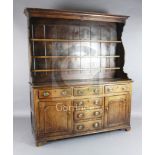 A George III oak dresser, with three shelf rack, six drawers and two panelled doors, W.5ft 10in. D.