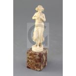 An Art Nouveau French ivory carved figure of a lady with a dove, raised on a hardstone base,