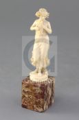 An Art Nouveau French ivory carved figure of a lady with a dove, raised on a hardstone base,