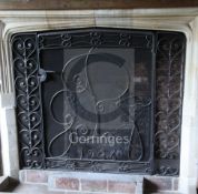 A large wrought iron and wire mesh spark guard, the single door worked with monogram G.P.T.,