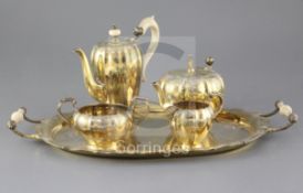 A George V silver gilt three piece coffee set and matching two handled oval tray, with later matched