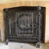 A large wrought iron scrollwork and wire mesh chimney piece spark guard, fitted with a pair of doors