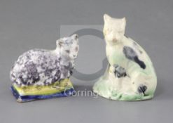 A Whieldon type creamware figure of a cat, c.1780 and a tinglaze figure cat on a cushion, possibly