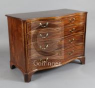 A George III satinwood banded mahogany serpentine commode, the top drawer fitted with a brushing