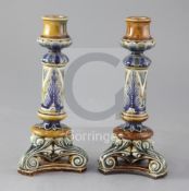 A pair of Doulton Lambeth stoneware candlesticks, decorated by Frank Butler, with stylised foliate