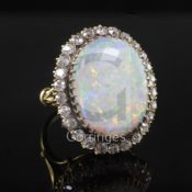 An 18ct gold, white opal and diamond oval cluster ring, the opal measuring approximately 20mm in