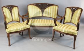 A French Art Nouveau mahogany three piece salon suite, in the manner of Majorelle, carved with