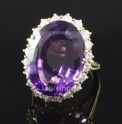 An 18ct gold, amethyst and diamond oval cluster ring, size K.