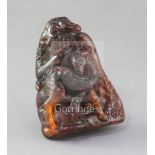 A Chinese amber boulder carving, Qing dynasty, carved in high relief with two deer and a faun beside