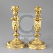 A pair of mid 19th century French ormolu candlesticks, each modelled with three bacchanalian figures