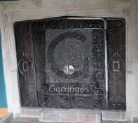 A heavy wrought iron chimneypiece spark guard, fitted a pair of doors with fork and circle design