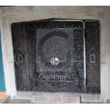 A heavy wrought iron chimneypiece spark guard, fitted a pair of doors with fork and circle design