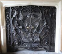 A black painted wrought iron and wire mesh chimneypiece spark guard, fitted with a pair of doors,