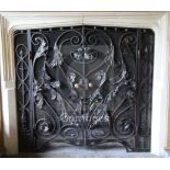 A black painted wrought iron and wire mesh chimneypiece spark guard, fitted with a pair of doors,