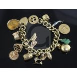 An 18ct gold curblink charm bracelet hung with fifteen assorted charms including 9ct gold and gold