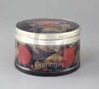 A Moorcroft pomegranate pattern circular trinket box, with silver plated mounts, green WM signature,