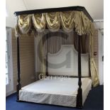 A George III STYLE mahogany four poster bedstead, with yellow silk drapes,