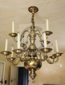 A late 19th century Dutch brass twelve light chandelier, with ball and baluster stem supporting