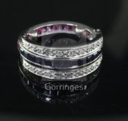 A white gold, ruby, sapphire and diamond set triple band swivel ring, set with shaped cut corundum