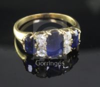 A gold, three stone sapphire and six stone diamond half hoop ring, set with oval sapphires and round