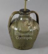 A French medieval green glazed jar, of squat globular form with twin strap handle, fitted for