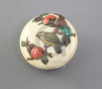 A Japanese shibayama and ivory manju netsuke, 19th century, decorated with a bird amid fruiting