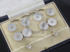 A cased early/mid 20th century 9ct gold and mother of pearl eight piece dress stud set.