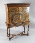 A William and Mary laburnum oyster veneered and crossbanded cabinet on stand, with cushion drawer,