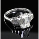 A 1930's/1940's Art Deco platinum and single stone emerald cut diamond ring, with graduated baguette