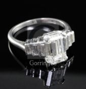 A 1930's/1940's Art Deco platinum and single stone emerald cut diamond ring, with graduated baguette