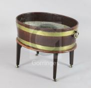 A George III brass bound mahogany oval wine cooler, with brass loop handles on stand, with fitted