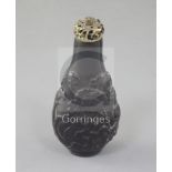 A Chinese jet pear-shaped snuff bottle, 19th century, carved in relief with flowers and rockwork,