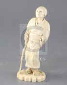 A Japanese ivory figure of an old lady, Tokyo School, Meiji period, holding a staff in her right