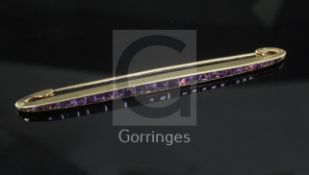 A French Cartier amethyst and 18ct gold bar brooch, channel-set with 29 square-cut amethysts, signed