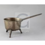 An 18th century bronze skillet, of characteristic form, the vessel raised on three feet, the