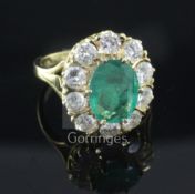 A modern 18ct gold, emerald and diamond oval cluster ring, size O.