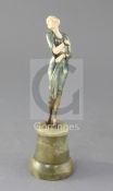 An Art Deco cold painted bronze and ivory figure of a Society lady, raised on a turned green onyx