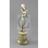 An Art Deco cold painted bronze and ivory figure of a Society lady, raised on a turned green onyx