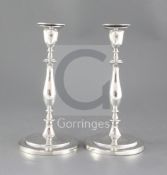 A pair of George III silver candlesticks, with engraved crest and waisted knopped stems on