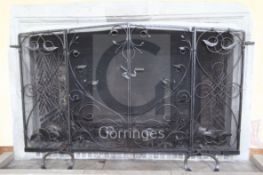 A large wrought iron and wire mesh chimneypiece spark guard, fitted with a pair of central doors,