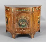 An Edwardian Sheraton revival painted satinwood demi lune side cabinet, with frieze drawer and