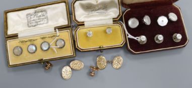 A pair of engraved yellow metal oval cufflinks, a set of three dress studs and three sets of dress