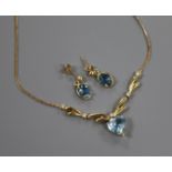 A heart-shaped aquamarine and diamond pendant on a yellow metal fine link chain and a pair of