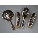 A George V silver and tortoiseshell four piece dressing table set, William Comyns & Sons, London,