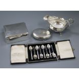 A circular silver tobacco box, a sauce boat, a cigarette box and a cased set of coffee spoons