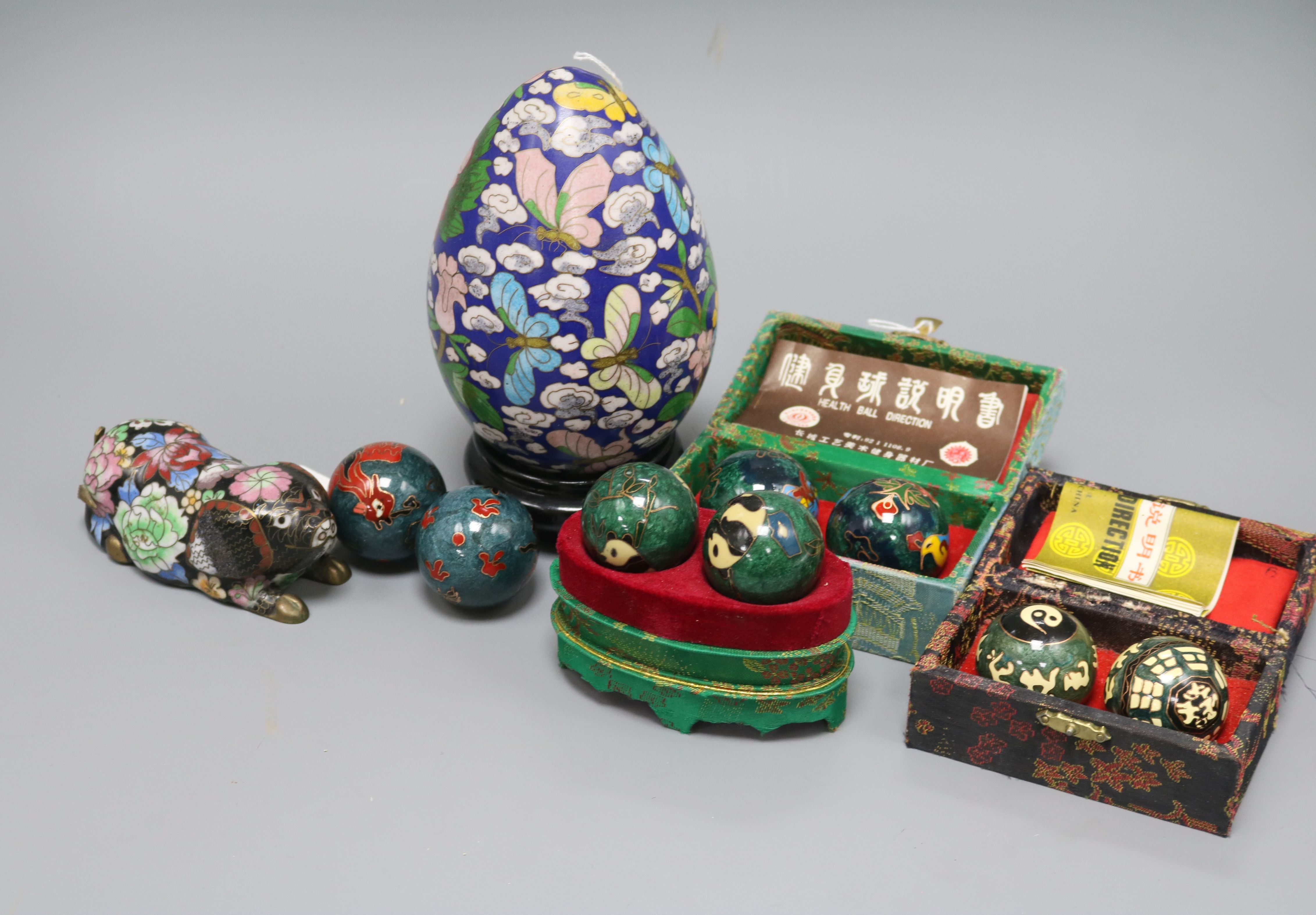 A Chinese cloisonne pig, four pairs of Baoding balls and a Japanese cloisonne egg on stand, the