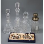A plated and glass cocktail shaker, three cut glass decanters and a pair of Royal Crown Derby